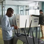 Homens preparam cabines de votação em uma seção eleitoral.