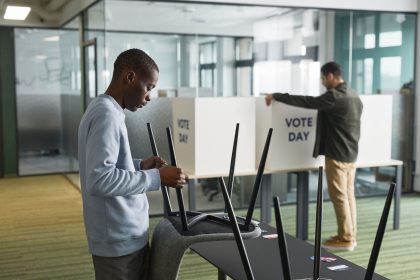 Homens preparam cabines de votação em uma seção eleitoral.
