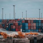 Contêineres coloridos empilhados em um movimentado porto industrial.