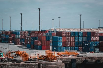 Contêineres coloridos empilhados em um movimentado porto industrial.