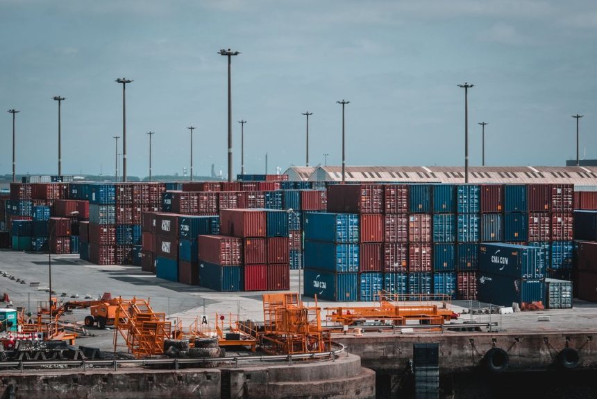 Contêineres coloridos empilhados em um movimentado porto industrial.