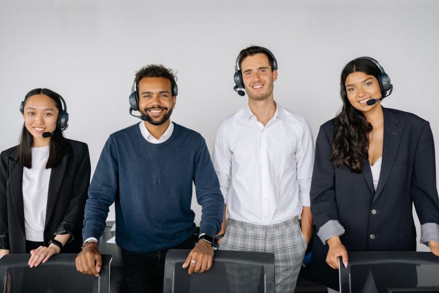 Grupo diversificado de atendentes de serviço ao cliente usando headsets em um escritório moderno